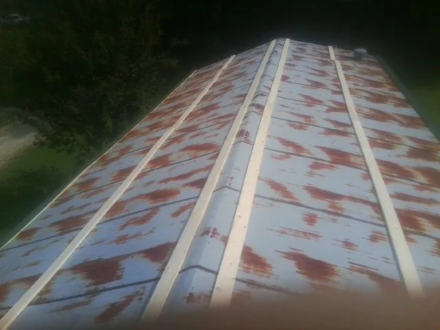 Rusted metal roof panels with new wood purlins before replacement — Storm Damage Roof Repair in Lapine by Roofing Brothers