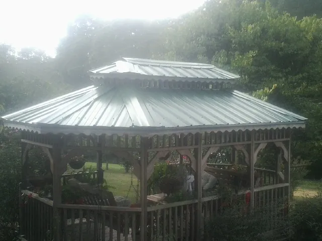 Two tier green metal roof on a garden gazebo in Lapine