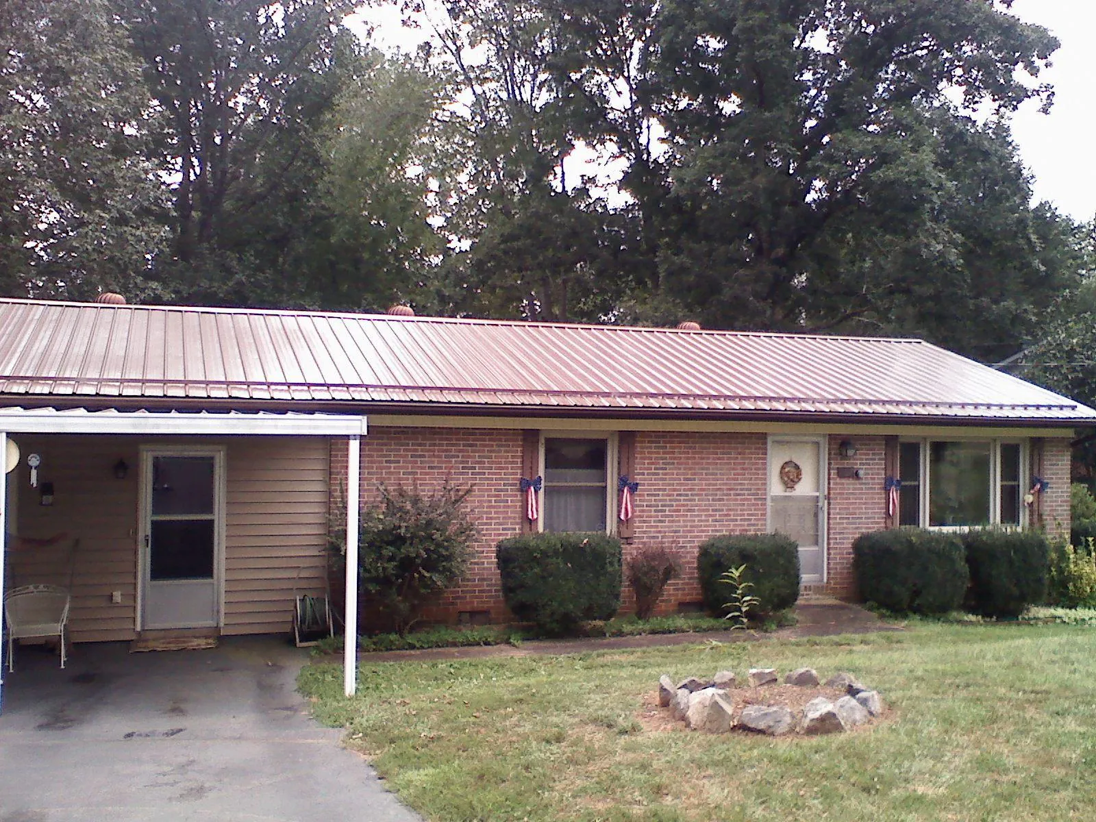 Bronze metal roof and carport on a brick ranch home — Roof Repair work by our crew in Lapine